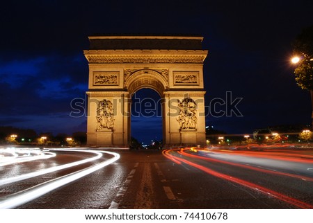 Beautifly lit Triumph Arch at night with light traces of passing cars. Paris, France.