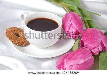 Breakfast with coffee and cookies, tulips on white silk