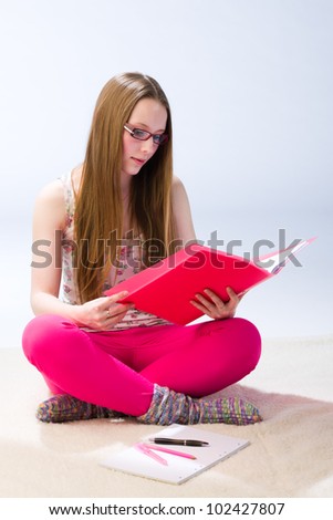Girl student reading and focuses on educational material
