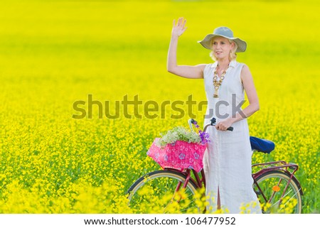 Woman waving hand, rapeseed on background