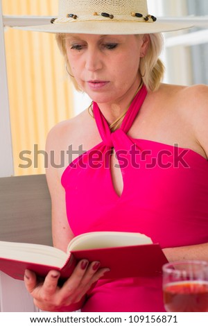 Lady reads a book on the veranda, reposeful atmosphere, vertical format