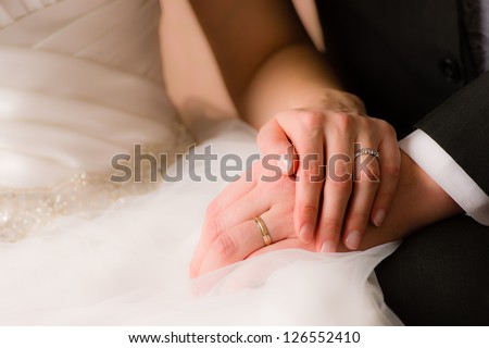 Closeup of a bride and groom holding hands