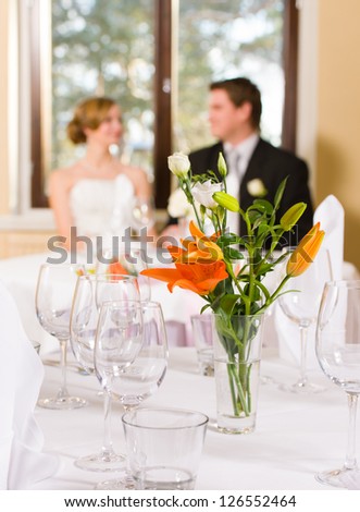 Table setting, bride and groom on background