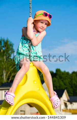 Young girl on the jungle gym, sunny day