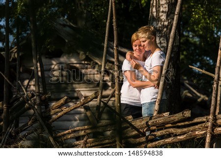 Lovely lesbian couple on behind the old fence, lovely sunshine