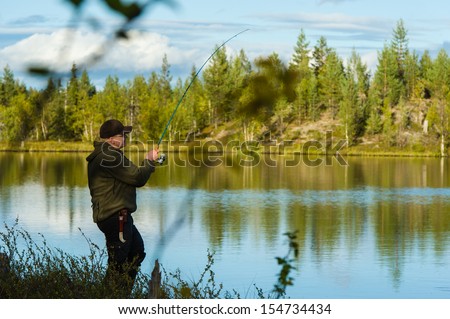 Fisherman on the little lake, beautiful landscape on background