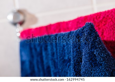 Two towels drying up on the wall rack