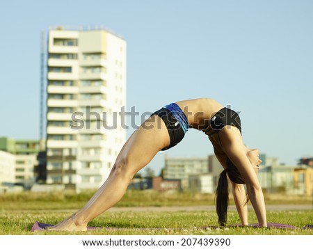 Active fitness woman working out in the park early in the morning, urban background
