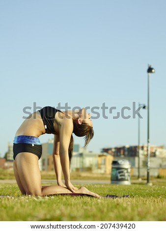 Active fitness woman working out in the park early in the morning, urban background