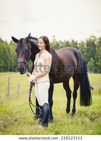 Attractive woman and horse in the field, cross processed image