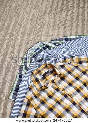Men\'s casual patterned shirts on the bed
