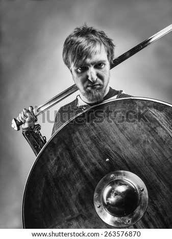 Angry medieval knight armor with a sword and shield, black and white image