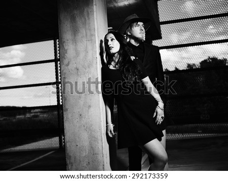 Man and woman together, concrete building surroundings, black and white image