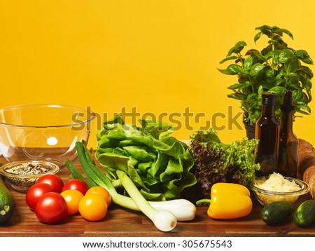 Fresh salad ingredients on the table, copy space and yellow background