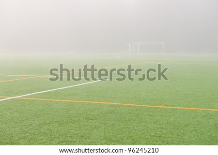 Empty soccer field early in the foggy morning.