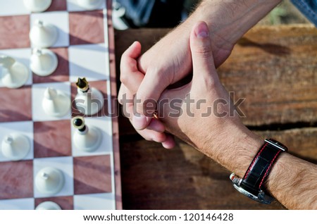 Hands of a chess player with board