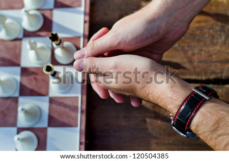 Hands of a chess player with board