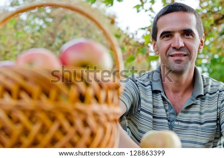 Smiling guy with a fruit basket in the park