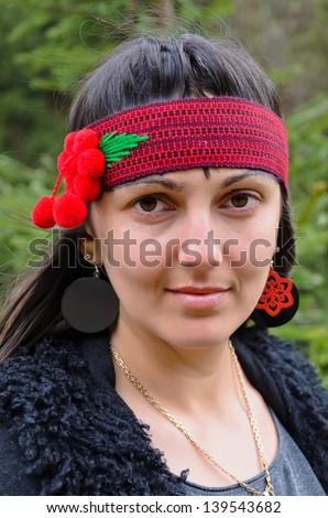Portrait of a pretty young hippie woman wearing a red headband decorated with flowers