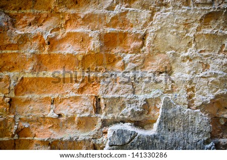 Background texture of an old wall of degraded clay bricks and fallen concrete