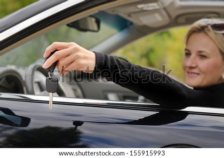 Matured woman giving a car key inside the car