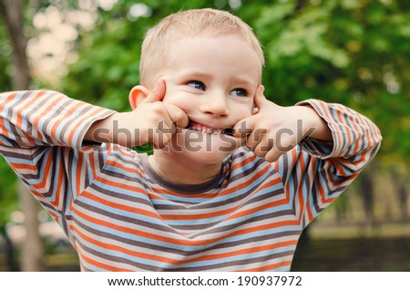 Cute young boy pulling a funny expression puckering up his lips with a look of amusement in his eyes