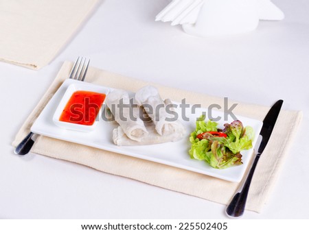 Close up Tasty Fresh Spring Rolls Main Dish with Lettuce and Dipping Sauce on White Rectangular Plate
