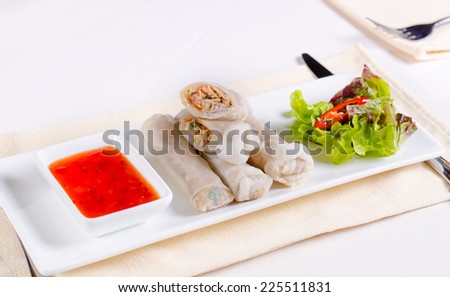 Gourmet Meaty Chinese Spring Rolls Main Dish with Sweet Chili Dipping Sauce and Fresh Lettuce on White Rectangular Plate