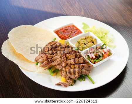 Grilled sliced Mexican beef fajitas served with a variety of savory sauces, salsa and tortillas