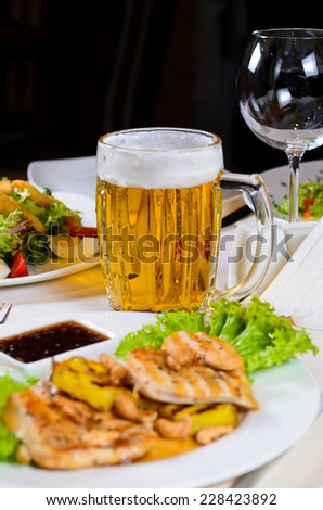 Mug of Beer Amidst Plated Dishes on Restaurant Table