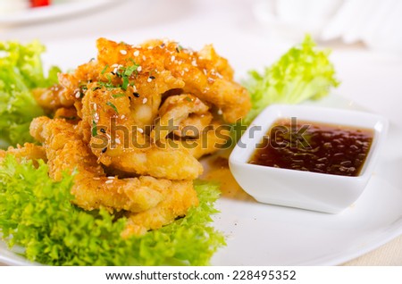 Close up Gourmet Fried Chicken Meat Dish with Sweet Chili Dipping Sauce and Fresh Lettuce on White Plate.