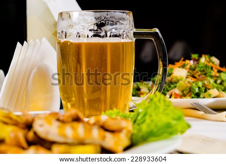 Close Up of Mug of Beer on Restaurant Table with Plated Food