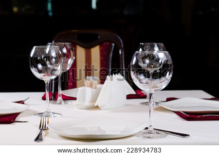 Table in Fancy Restaurant Set for Dinner with Wine Glasses