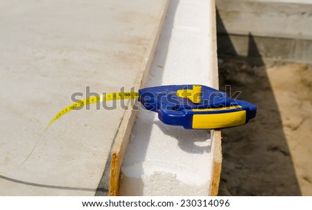 Builders tape measure on an insulating wall being installed in a new build house on a building site