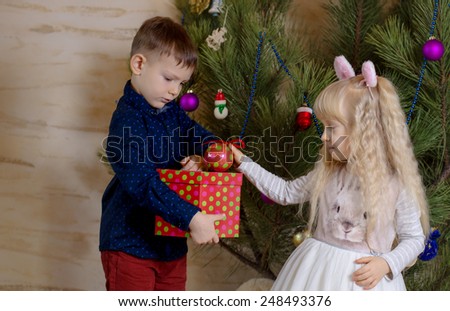 Close up White Kids Preparing Christmas Tree with Colored Christmas Balls from the Box.