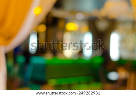 Warm yellow lights and white neon in a blurred interior of a fancy location for food and drinks as a restaurant, cafeteria or bar