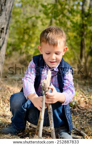 Close up Cute Little Boy in Autumn Outfit Playing with Sticks on the Ground at the Woodland