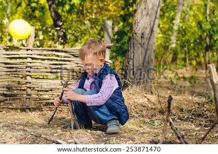 Close up Cute Little Boy in Autumn Outfit Playing with Sticks on the Ground at the Woodland
