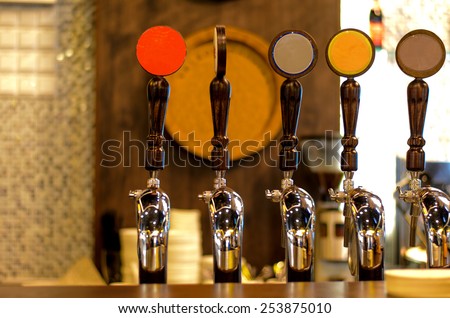 Close Up of Row of Shiny Beer Taps of Different Brews in Bar