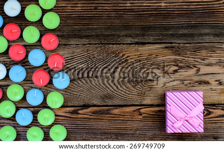 Gift box with candles on wooden background
