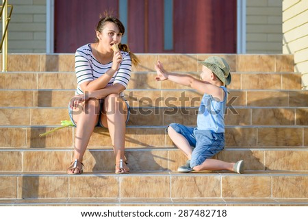 Young Boy Begging for Taste of Mothers Ice Cream Cone, Sitting Together on Front Steps of Home