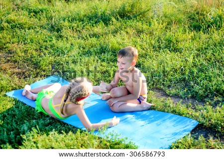 Two Happy Cute White Kids in Summer Outfits, Cuddling on Blue Mat at the Grassy Ground