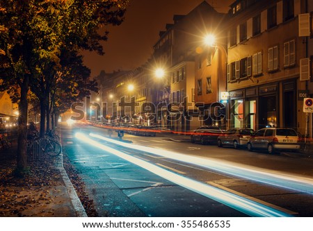 France, Strasburg-30 October 2015:Night city, roadway , cars are parked along the road lighting street lights blurred traces of headlights of passing cars
