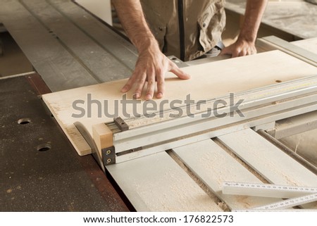 hands of a worker while cutting with circular saw