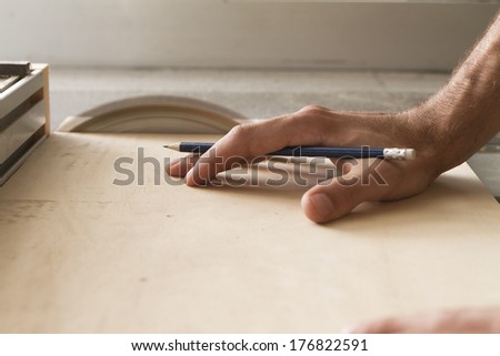 hand of a worker while cutting with circular saw