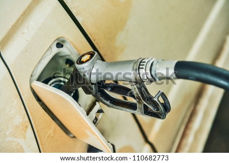 Refilling the dirty car with fuel on a filling station