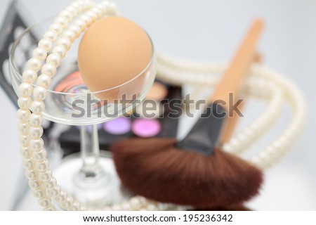 Decorative cosmetics makeup. pink,yellow,blue, brush pearl egg cosmetics on table, violet