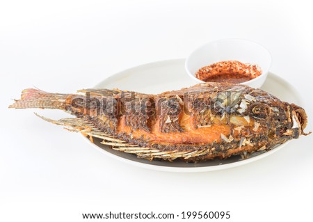 Deep Fried Tilapia fish fried with sauce spicy appetizing food on white plate in studio