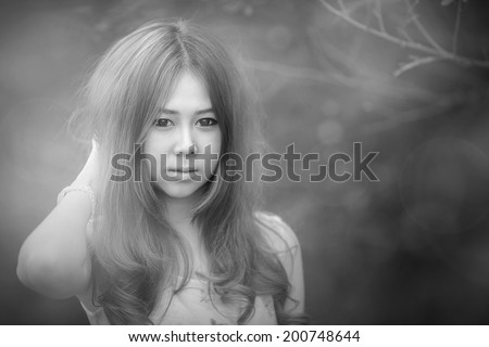 Black and white sexsy lovely  beautiful young asian girl smile garden with sunlight gray picture portrait of young woman touch her hair in the park
