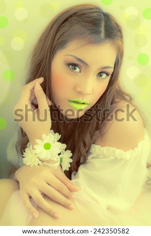 Mouth Lime Asian fashion.   Hand with flowers bokeh 	Professional makeup. Luxurious green bokeh .,LEMON-GREEN , young woman with flowers in their hand